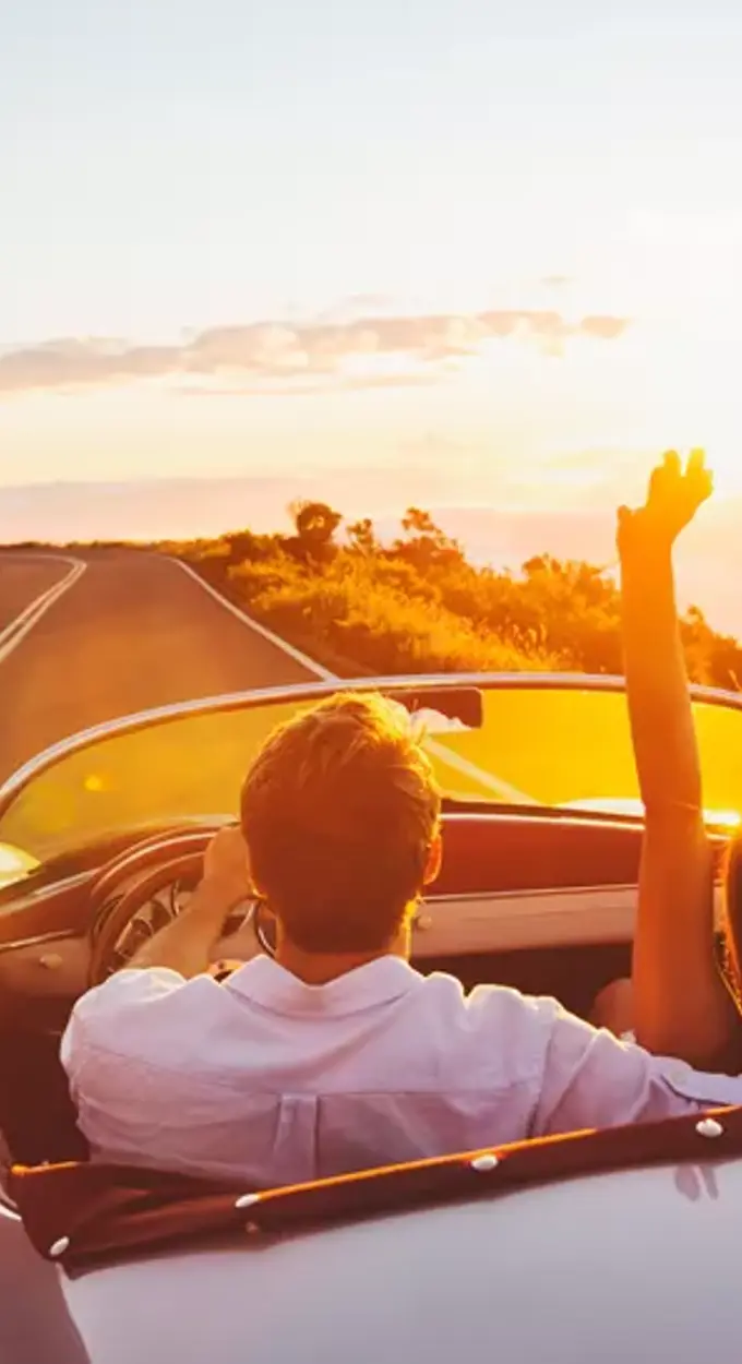 Mensen in auto rijdend bij zonsondergang